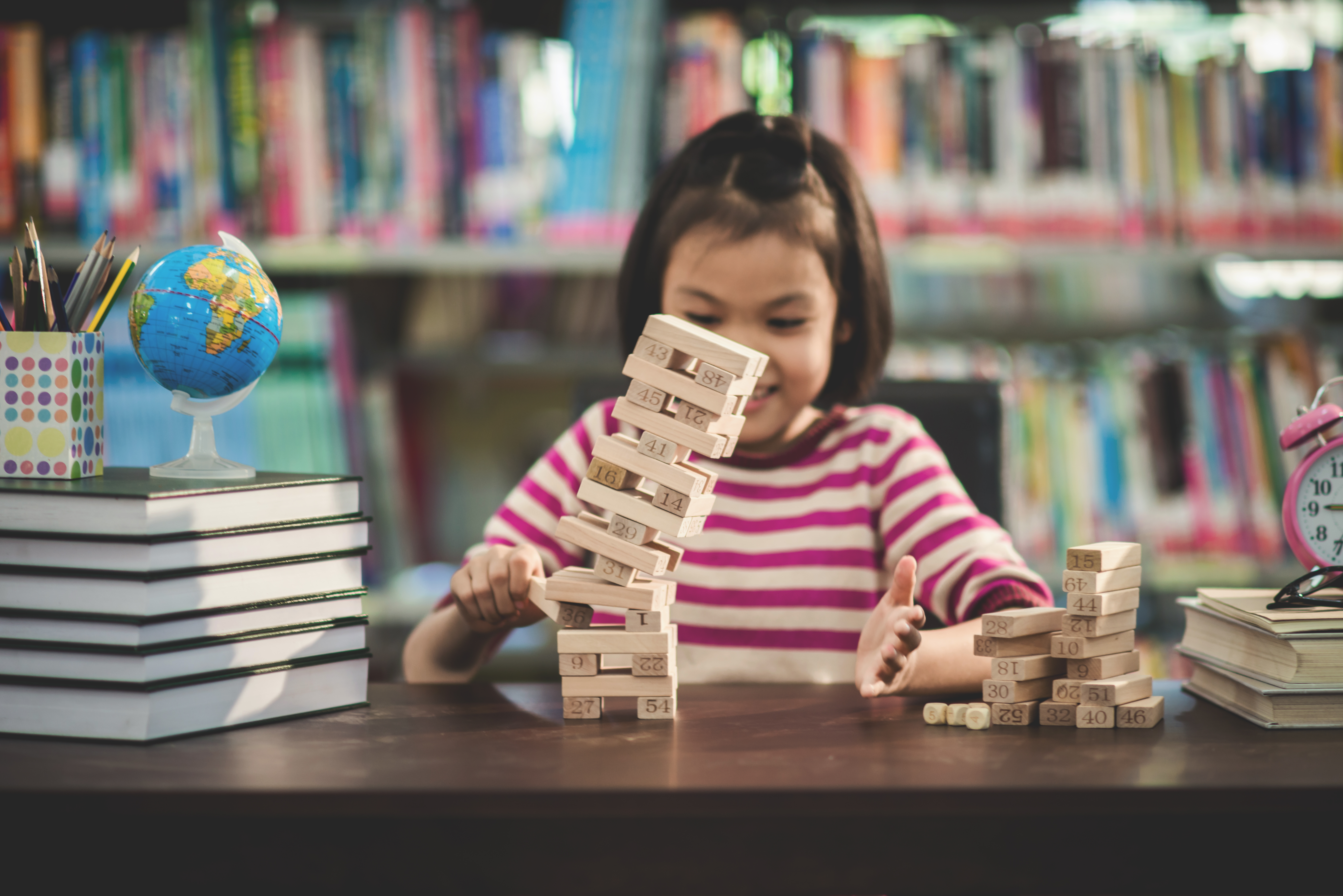 portrait of kid cute asian girl happy to play blocks wood game a